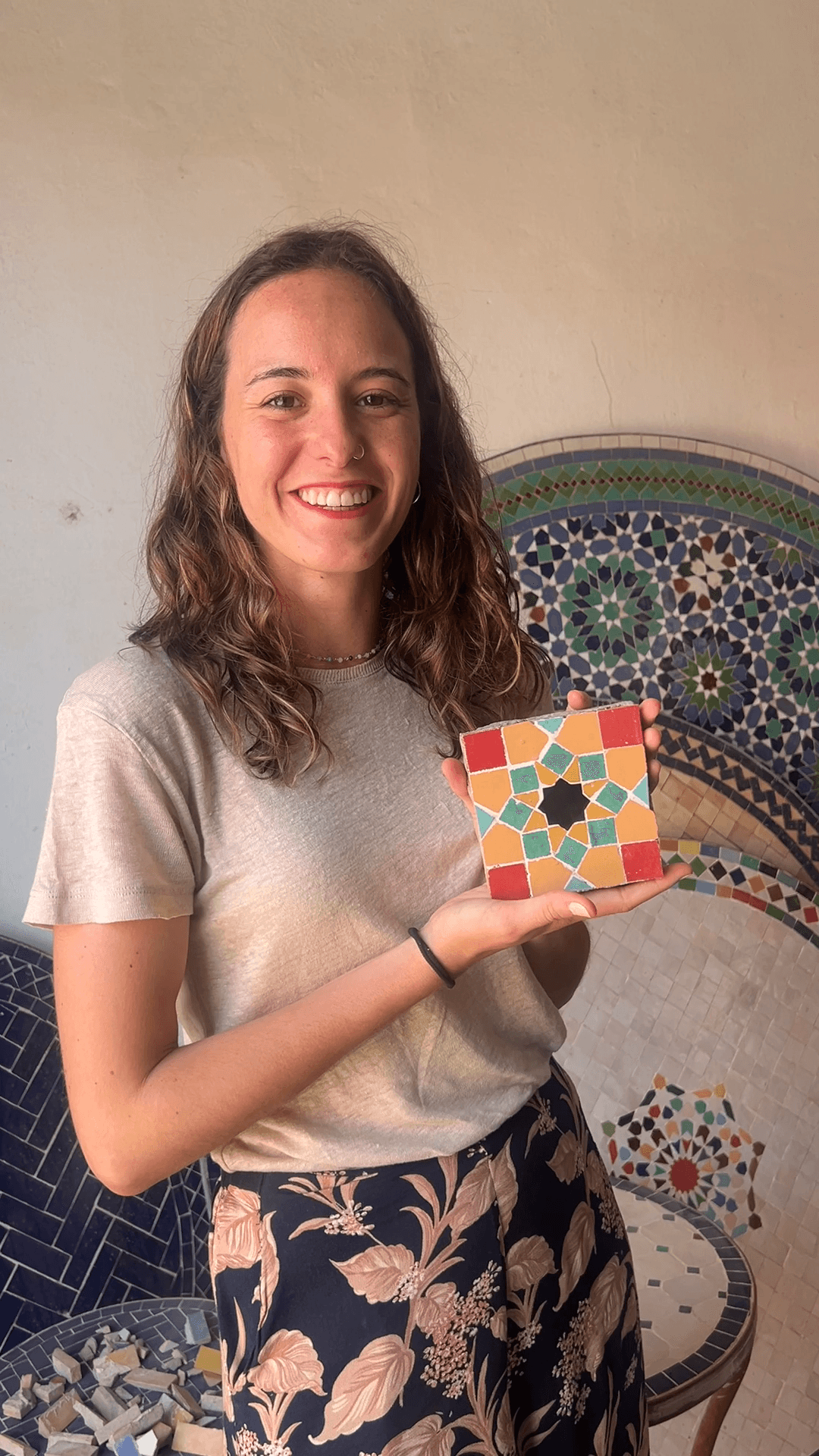 Una estudiante muestra el azulejo de zellige hecho en un taller cultural