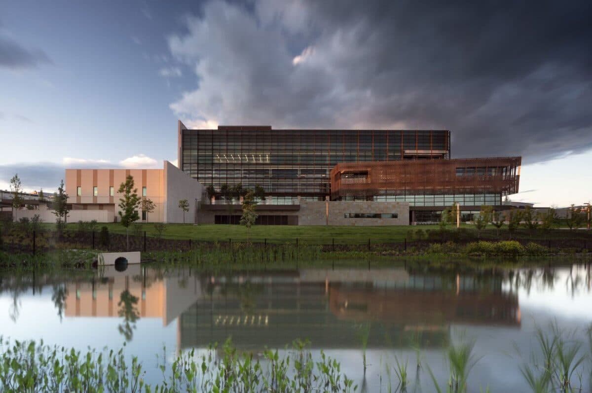 A modern government building in Rabat mirrored in a landscaped pond under a dramatic sky